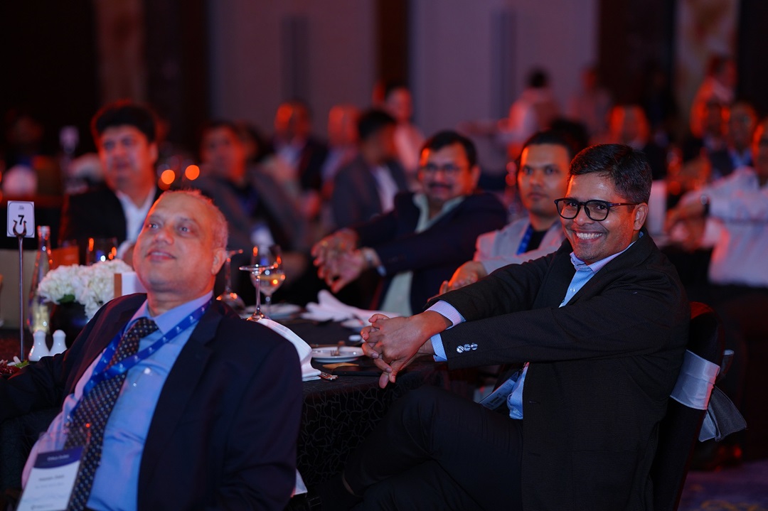 Attendees seated at round tables during the Orbus Dubai Launch Celebration, attentively watching a presentation. Several individuals are smiling.