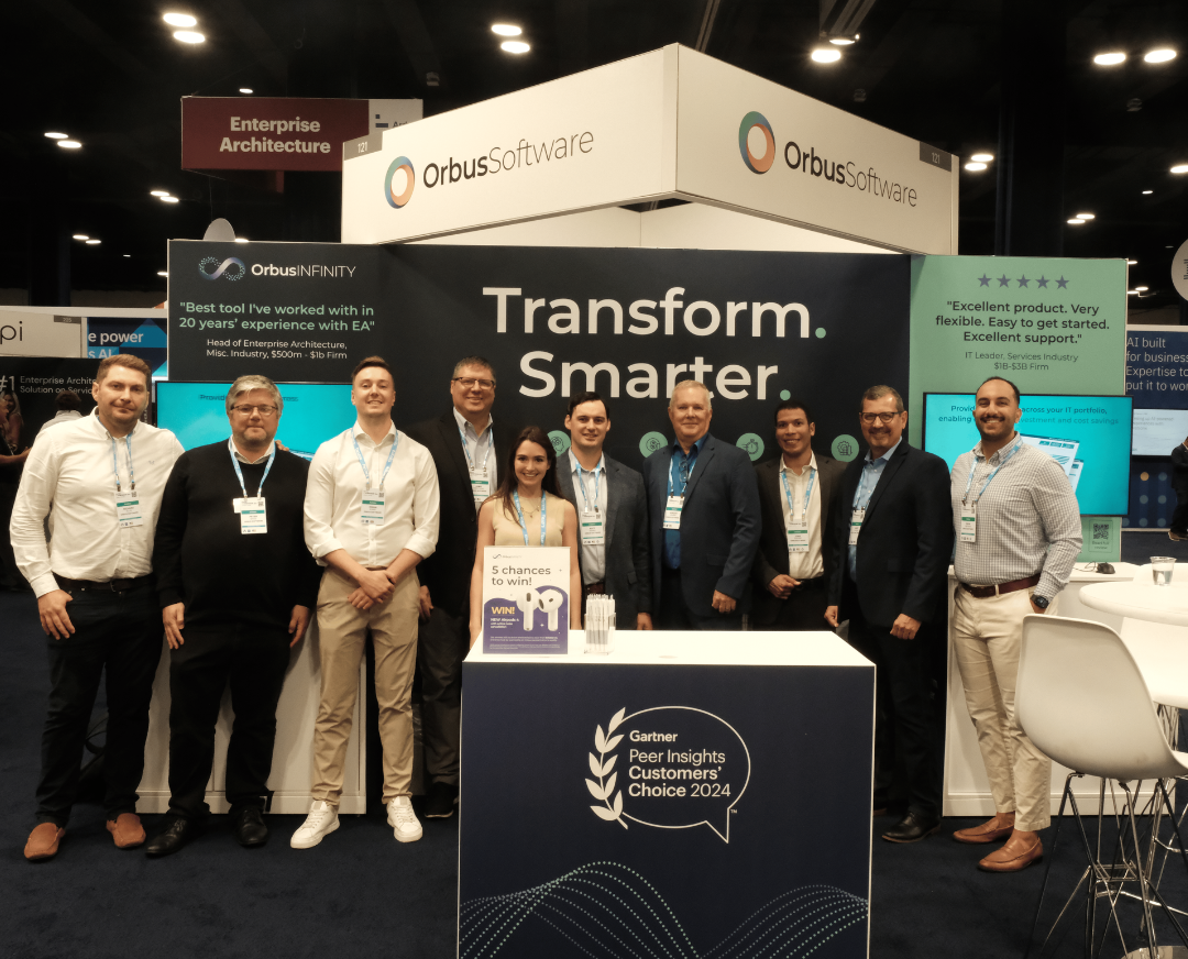 Group photo of the Orbus Software team standing at their exhibition booth at the Gartner IT Symposium/Xpo 2024 in Orlando.